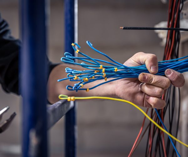 a-male-electrician-works-in-a-switchboard-with-an-electrical-connecting-cable-1-1